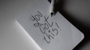 Inspirational handwritten note on graph paper with pen. Encouraging words 'You got this!'